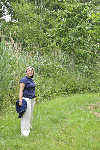 Abby staat links naast hoog riet op gras